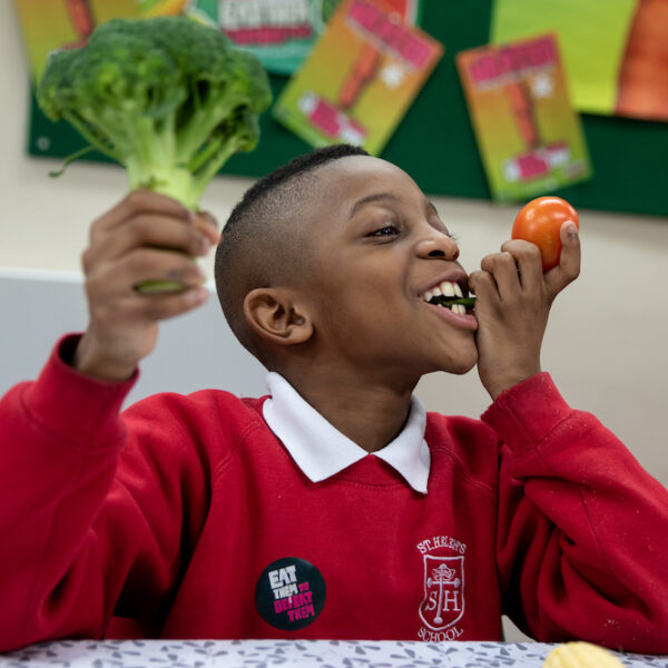 St Helen's boy eating veg holding broccoli - square supporters sign up
